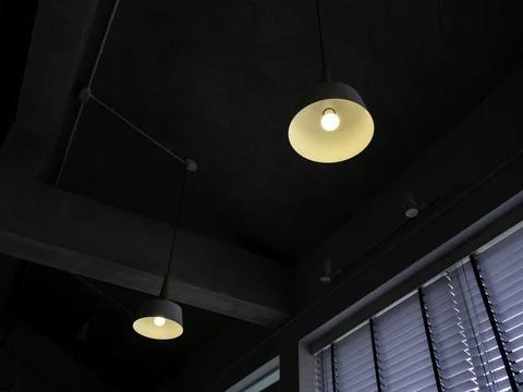 Modern round ceiling light with light bulb hanging from concrete construction Stock Photos