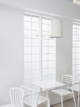 Modern round light lamp cylindrical shape hanging from ceiling over empty t.. Stock Photos