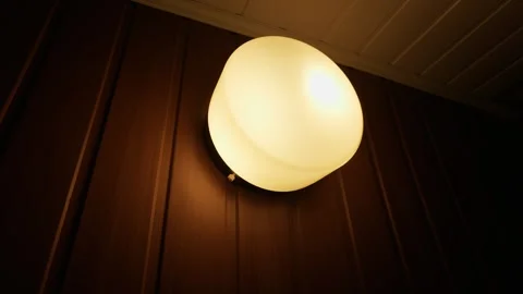 Modern Round Outdoor Wall Light Glowing on Brown Residential Siding Видео 335638993