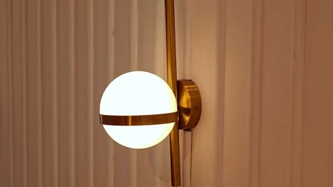 Modern round wall lamp, bulbs ball shape with gold metallic centerpiece. Stock Footage 307593389