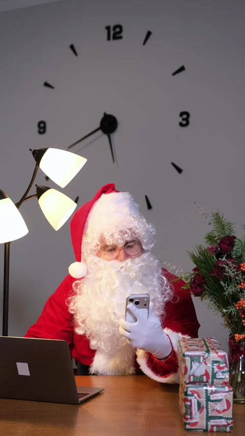 Modern santa claus checking wish lists on his smartphone Stock Footage 323915981