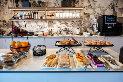 Modern self serve breakfast counter with pastries and fruit display Stock Photos