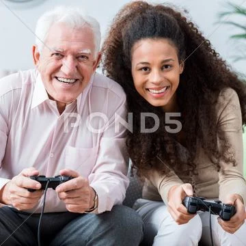 Modern senior playing on console Stock Photos