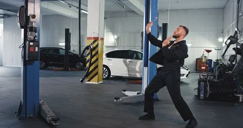 Modern service auto mechanic guy dancing very excited in front of the camera Stock Footage 119075322