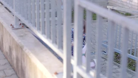 A modern setting featuring an Urban Gray Fence along with a Paved Walkway Stock Footage 311117628