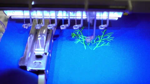 Modern sewing machine makes embroidery on blue fabric Stock Footage 85655474