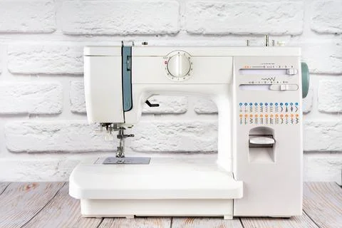 Modern sewing machine on table in tailor's workshop Stock Photos