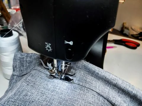 Modern Sewing Machine in Use with Gray Fabric Stock Photos