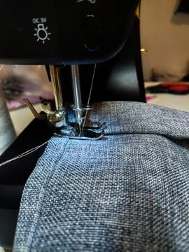 Modern Sewing Machine in Use with Gray Fabric Stock Photos