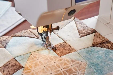 Modern sewing machine  working on a patchwork block of quilt Stock-Fotos