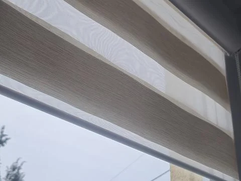 A modern sheer roller blind gently filtered light into a bright room, creating a Stock-Fotos