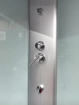 A modern shower panel features shiny chrome fixtures and a minimalist design Stock Photos