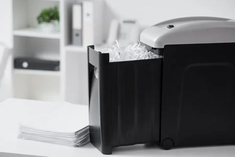 Modern shredder with documents on desk in office, closeup Stock Photos