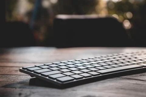 Modern silver bluetooth keyboard on an old wooden table Stock Photos