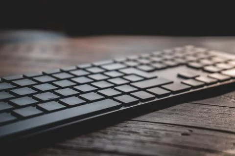 Modern silver bluetooth keyboard on an old wooden table 写真素材