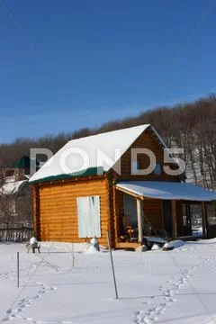 Modern Simple Wooden Summer Cottage With A Roof Covered With Snow In The Vill