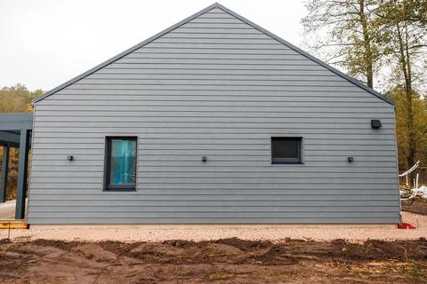 Modern single story house with sharp gable and gray cladding Stock Photos