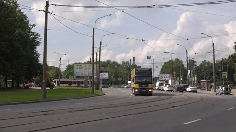 Modern single tram of route 23 and heavy truck turning along road curves Stock Footage 67468217