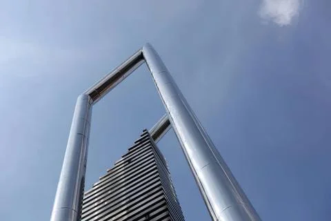 Modern skyscraper building with unique arch design in city Photos