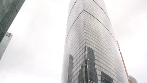 A modern skyscraper designed with a reflective glass facade that captivates Vidéo 294160957