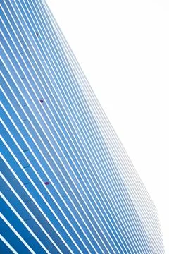 Modern skyscraper facade of blue panels and white diagonal stripes forms Stock Photos