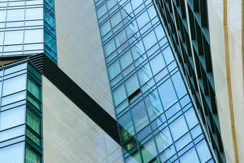 Modern skyscraper facade with geometric patterns of glass and stone textures Stock Photos