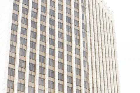 Modern skyscraper facade with repeating windows and vertical lines against .. Stock Photos