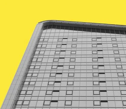Modern skyscraper facade with square windows against bright yellow background Stock Photos