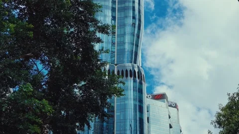 A modern skyscraper framed by an old stone bridge arch, reflecting in glass 库存影片 338311523