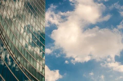 Modern skyscraper with reflections of clouds on windows, details Stock Photos