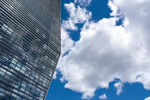 Modern skyscraper with reflections of clouds on windows Stock Photos