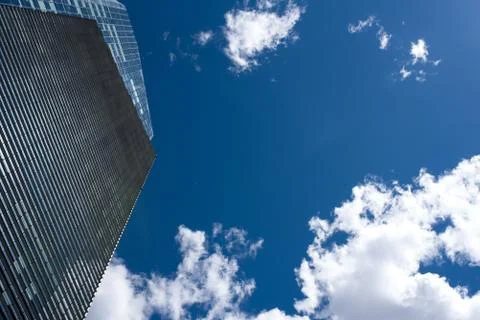Modern skyscraper with reflections of clouds on windows Stock Photos