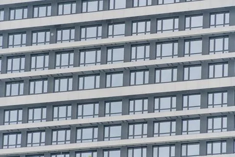Modern skyscraper with repetitive square windows, black framing, and a gray.. Stock Photos