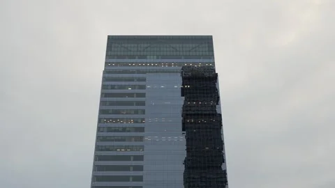 A modern skyscraper rises elegantly under the backdrop of a cloudy sky 動画素材 295074852
