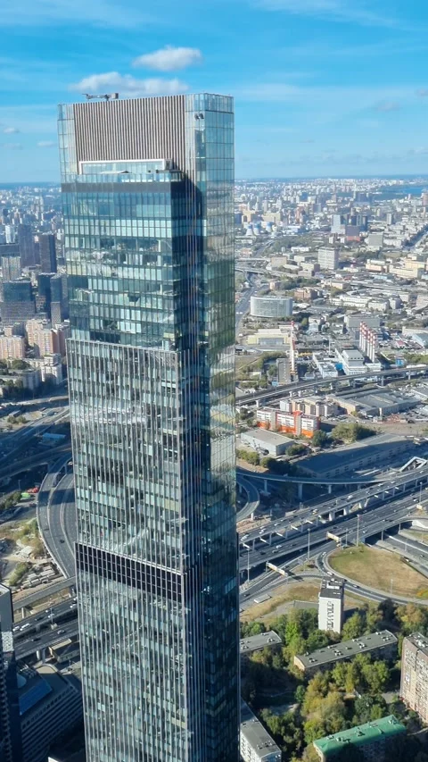 Modern skyscraper towering over city center with traffic on highway. Moscow Stock Footage 286027176