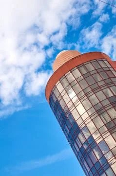 Modern skyscraper with a unique round shape, cloudy sky background, copy spac Stock Photos