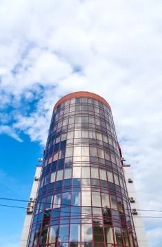 Modern skyscraper with a unique round shape, cloudy sky background, copy spac Stock Photos