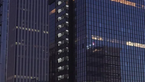 Modern skyscraper windows reflecting city life at twilight Stock Footage 329592762
