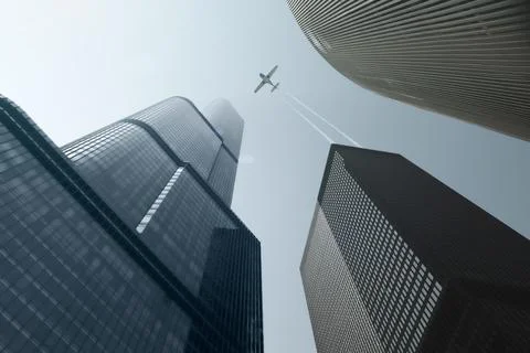 Modern Skyscrapers And Single Engine Plane With Trails Over Blue Sky Foto stock
