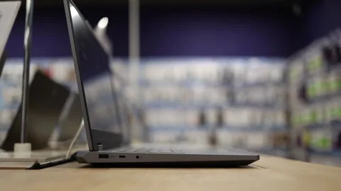 Modern slim laptop displayed open on table inside an electronics retail store Stock Footage 345359430
