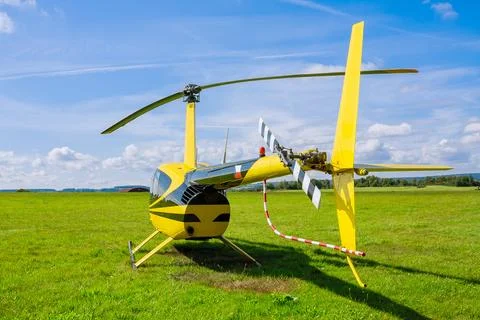 Modern small light helicopter on a grassy field against the blue sky. Top wiev Stock Photos