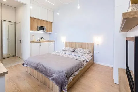 Modern small studio bedroom with bed and kitchenette Stock Photos