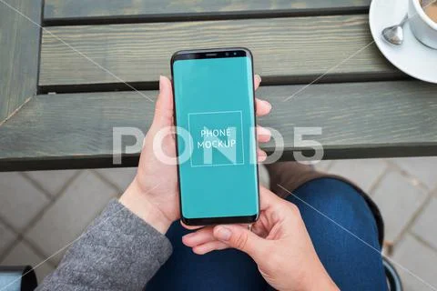 Modern smart phone mockup in woman hands close-up. Top view, flat lay PSD-Vorlage