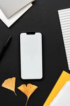 Modern smartphone on black table background with nature decoration, yellow .. Stock Photos
