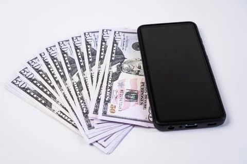 A modern smartphone with a blank black screen placed next to a neatly fanne.. Stock Photos