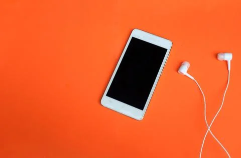 Modern Smartphone with Blank Screen and Earphones on orange Background Stock Photos