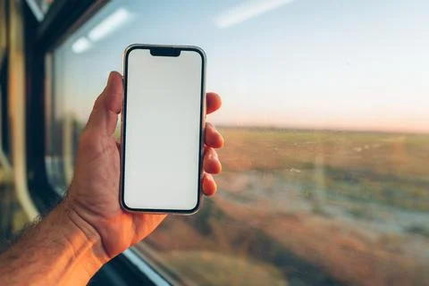 Modern smartphone held inside a train carriage for an online ticket booking.. Stockfoto's