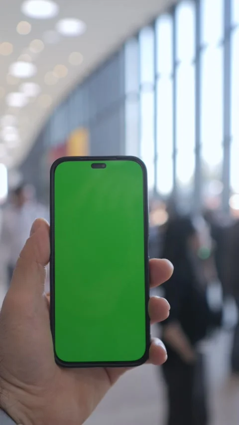 A modern smartphone showcasing a vibrant green screen display set in a Stock Footage 296735735