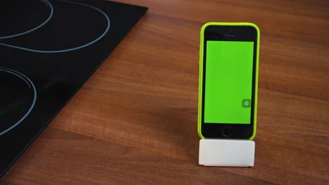 Modern smartphone in vertical position on stand, green empty screen. Mobile appl Stock Footage 162613371