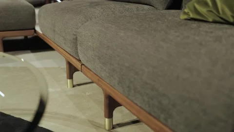 A modern sofa, with gray frame and wooden legs and gold elements, which Stock Footage 311255609